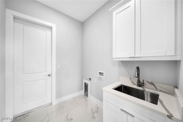 clothes washing area featuring baseboards, washer hookup, cabinet space, marble finish floor, and a sink