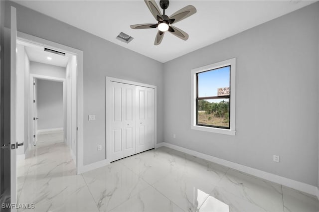 unfurnished bedroom featuring baseboards, visible vents, ceiling fan, a closet, and marble finish floor