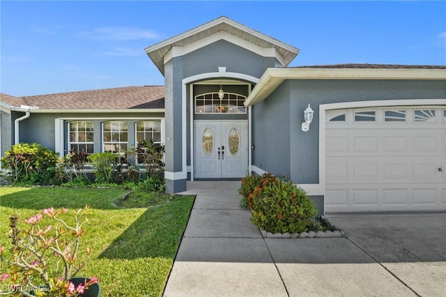 2218 NE 5th Ter, Cape Coral, FL 33909 - view of exterior entry featuring a yard, an attached garage, concrete driveway, and stucco siding