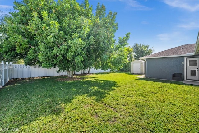 2218 NE 5th Ter, Cape Coral, FL 33909 - view of yard with a storage unit, a fenced backyard, and an outdoor structure
