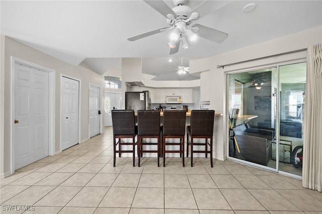 2218 NE 5th Ter, Cape Coral, FL 33909 - dining room featuring light tile patterned floors, baseboards, vaulted ceiling, and ceiling fan