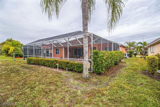 20854 Wheelock Dr, North Fort Myers, FL 33917 - rear view of property with a lanai and a lawn