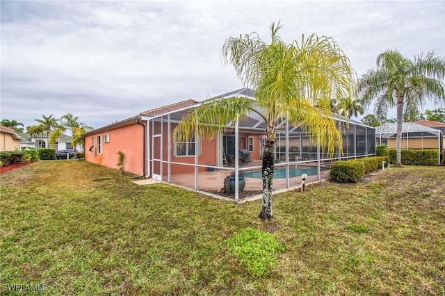 20854 Wheelock Dr, North Fort Myers, FL 33917 - rear view of house with glass enclosure, a yard, an outdoor pool, and stucco siding