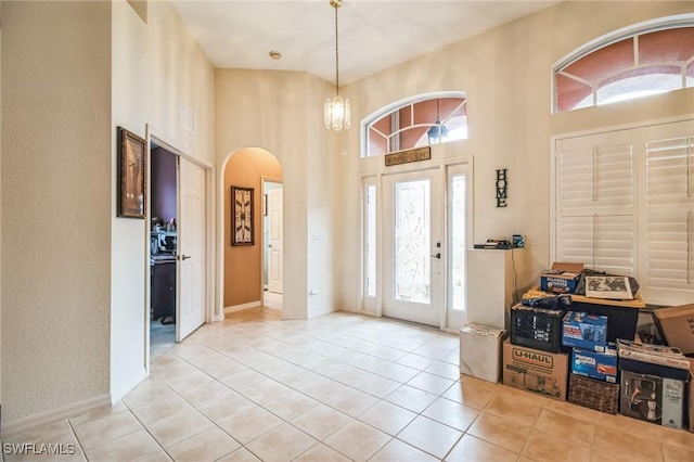 20854 Wheelock Dr, North Fort Myers, FL 33917 - tiled foyer entrance featuring visible vents, baseboards, a chandelier, a towering ceiling, and arched walkways