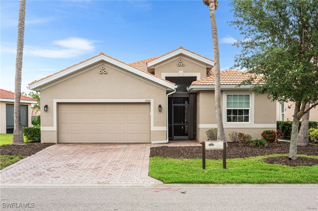 13104 Silver Thorn Loop, North Fort Myers, FL 33903 - view of front of house with decorative driveway, stucco siding, a garage, and a tiled roof