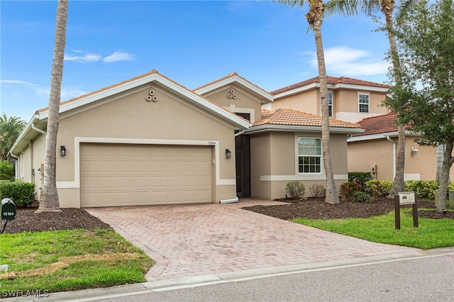 13104 Silver Thorn Loop, North Fort Myers, FL 33903 - view of front of home with a garage, stucco siding, decorative driveway, and a tile roof