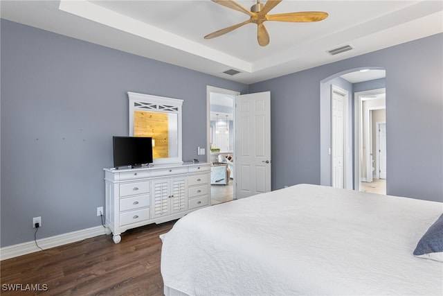 13104 Silver Thorn Loop, North Fort Myers, FL 33903 - bedroom featuring arched walkways, dark wood-style floors, a tray ceiling, baseboards, and a ceiling fan