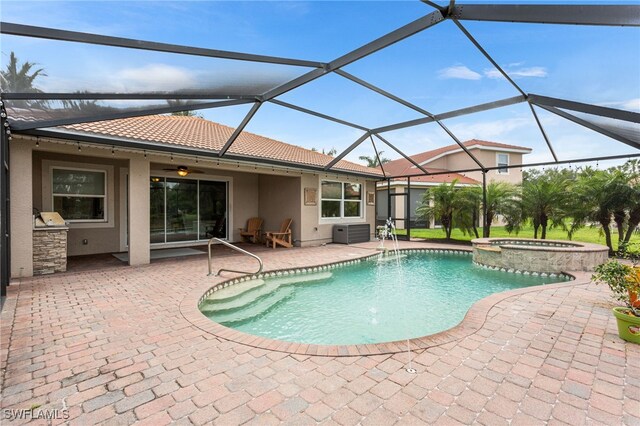 13104 Silver Thorn Loop, North Fort Myers, FL 33903 - view of swimming pool featuring exterior kitchen, a patio, ceiling fan, a pool with connected hot tub, and a lanai