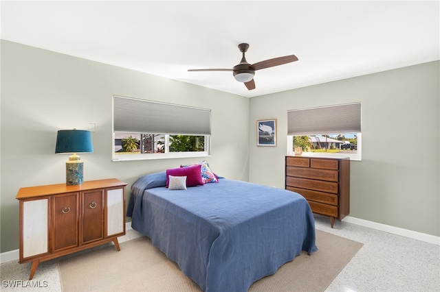 bedroom featuring multiple windows, light speckled floor, and baseboards