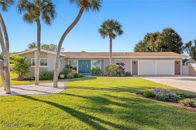 view of front of house with stucco siding, an attached garage, concrete driveway, and a front yard