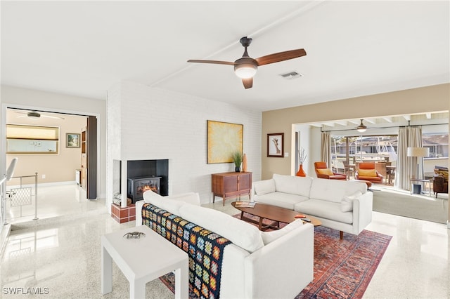 living area featuring visible vents, speckled floor, and ceiling fan