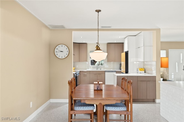 dining room with visible vents, light speckled floor, and baseboards