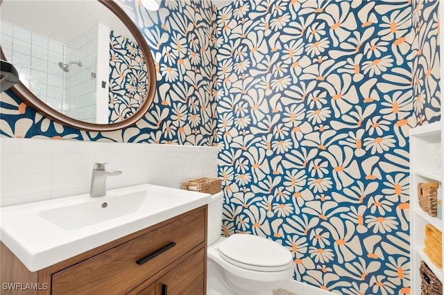 bathroom featuring vanity, tile walls, and toilet