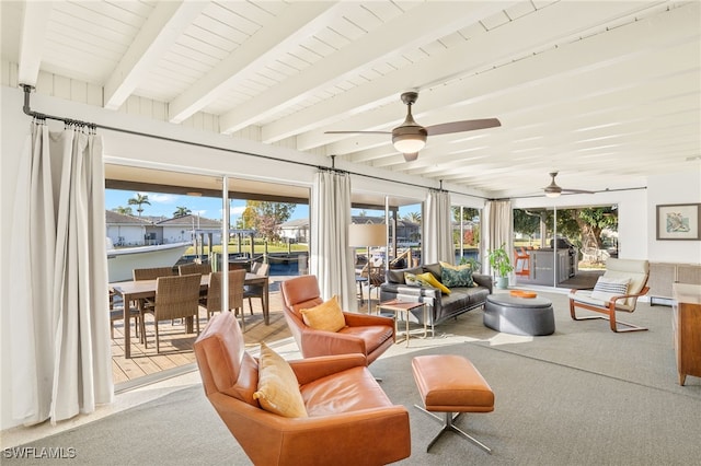 sunroom / solarium with beam ceiling, plenty of natural light, and ceiling fan