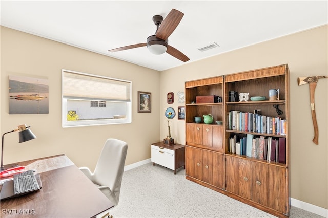 office space with visible vents, baseboards, speckled floor, and a ceiling fan