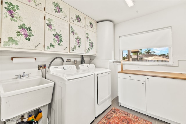 laundry area with washing machine and dryer, cabinet space, and a sink