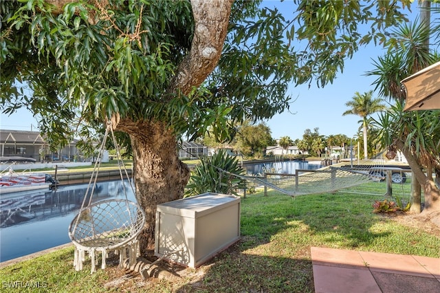 exterior space with a yard, fence, and a water view