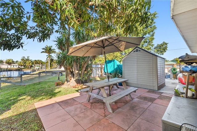 view of patio / terrace featuring an outbuilding, a shed, outdoor dining area, and a fenced backyard