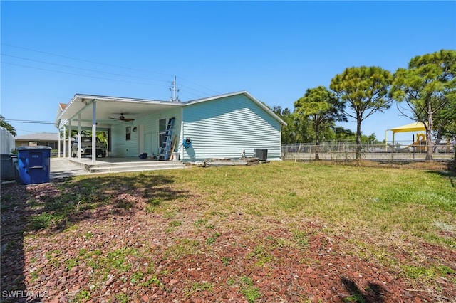 back of property featuring ceiling fan, fence, cooling unit, a yard, and a patio area