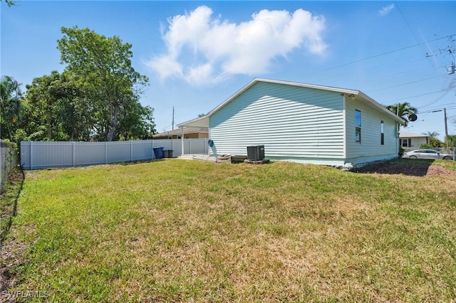 exterior space featuring central AC unit, a lawn, and a fenced backyard