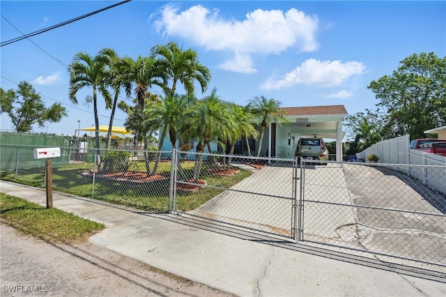 view of front of house with a fenced front yard, driveway, a gate, and a carport