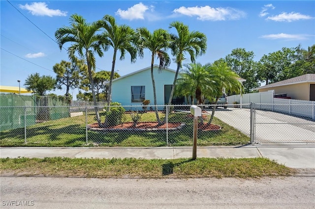 view of front of home with a fenced front yard, driveway, and a gate