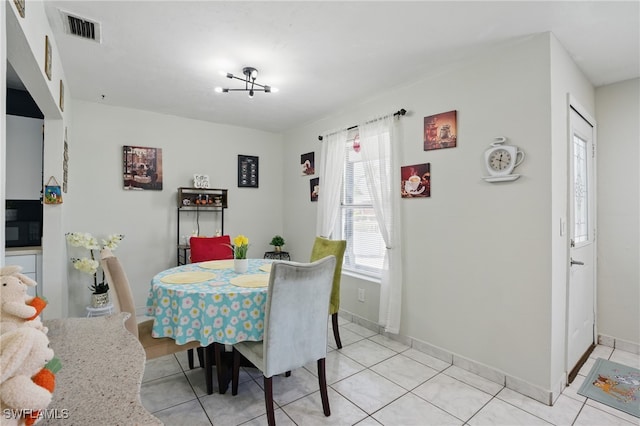 dining room with light tile patterned floors, visible vents, and baseboards