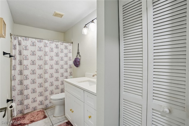 bathroom with visible vents, toilet, a closet, tile patterned flooring, and vanity