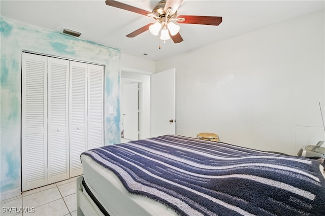 bedroom with light tile patterned floors, visible vents, ceiling fan, and a closet