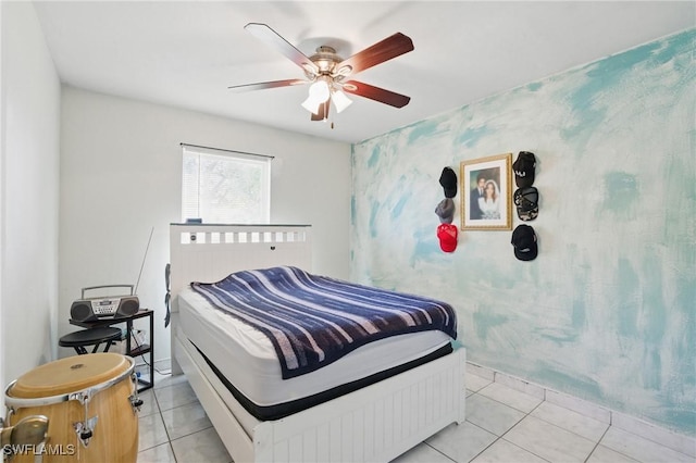 bedroom with wallpapered walls, light tile patterned floors, and a ceiling fan