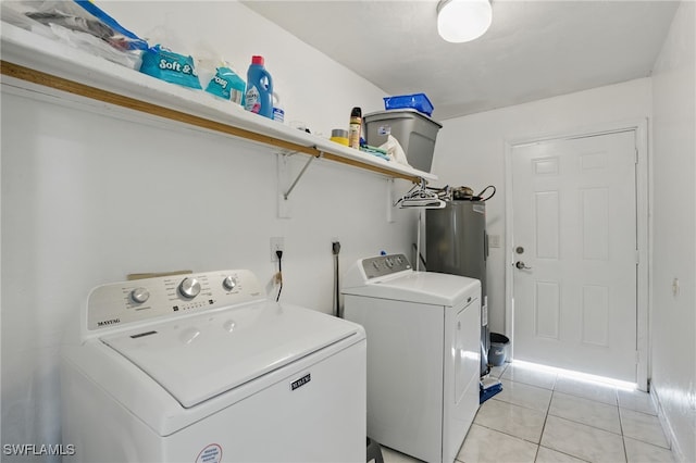 laundry room featuring light tile patterned floors, electric water heater, laundry area, and washing machine and clothes dryer