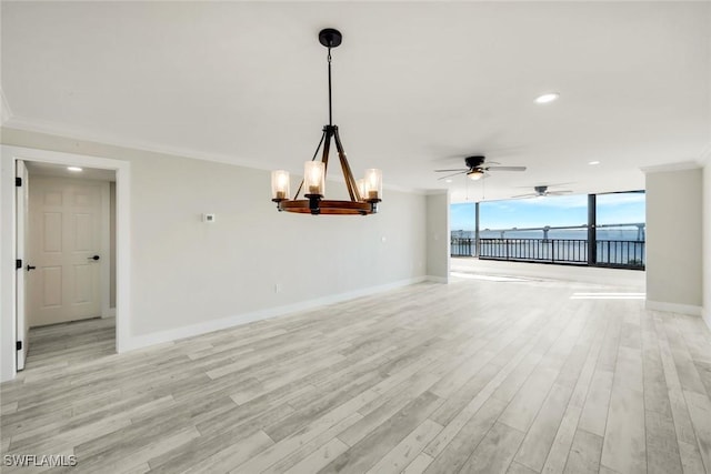 unfurnished living room featuring crown molding, light wood-style flooring, baseboards, and expansive windows