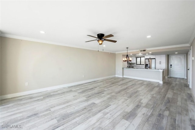 unfurnished living room with visible vents, light wood finished floors, baseboards, crown molding, and ceiling fan with notable chandelier