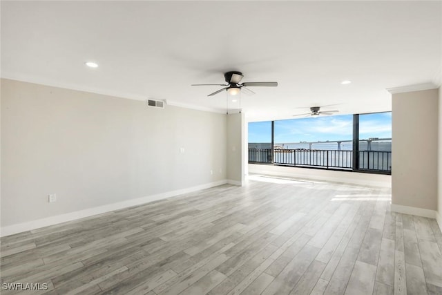 unfurnished room featuring baseboards, visible vents, light wood-style flooring, ceiling fan, and crown molding