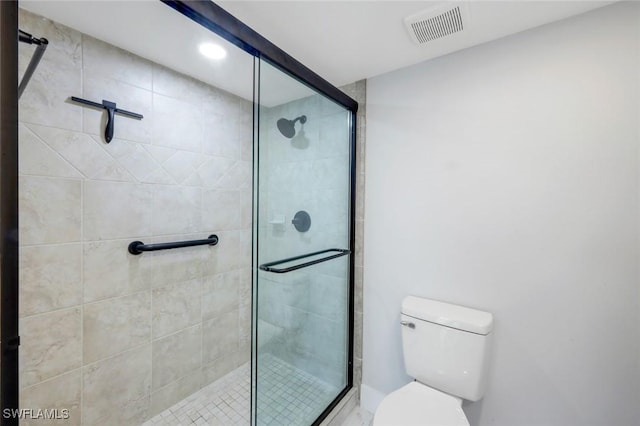 bathroom featuring a shower stall, toilet, and visible vents