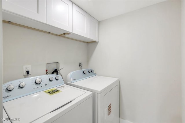 laundry area with cabinet space and separate washer and dryer