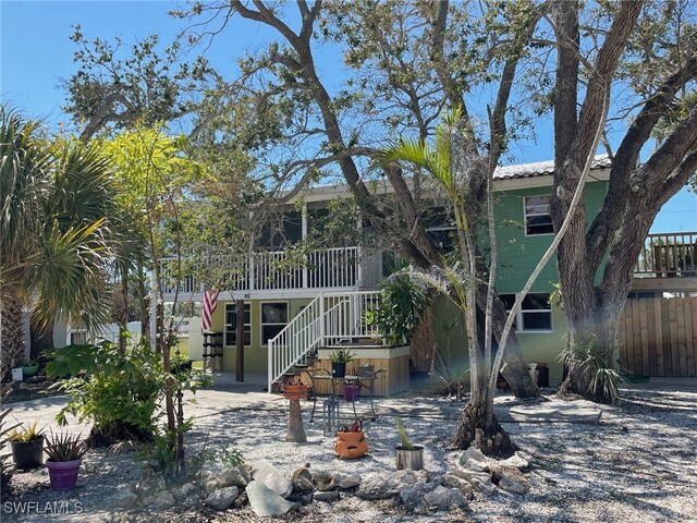 5460 Oak Ridge Ave, Fort Myers Beach, FL 33931 - view of front of home featuring stucco siding, stairway, fence, and a patio