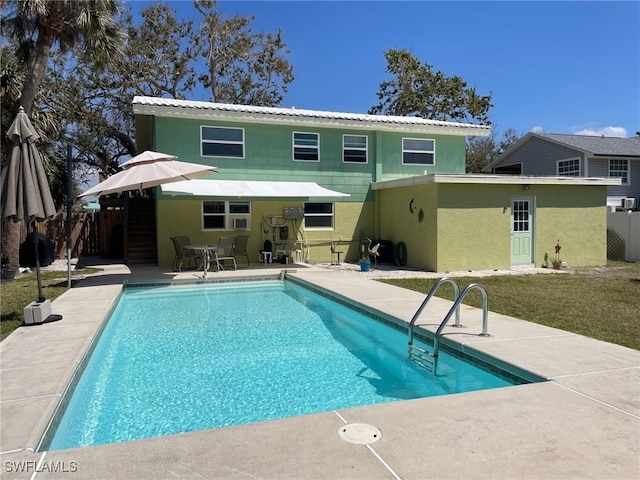5460 Oak Ridge Ave, Fort Myers Beach, FL 33931 - back of house with stucco siding, fence, a patio, and an outdoor pool