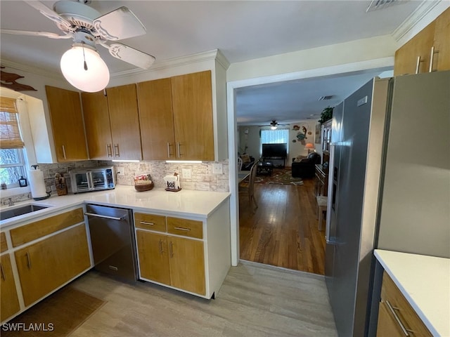 5460 Oak Ridge Ave, Fort Myers Beach, FL 33931 - kitchen with tasteful backsplash, a sink, ceiling fan, light wood-style flooring, and appliances with stainless steel finishes