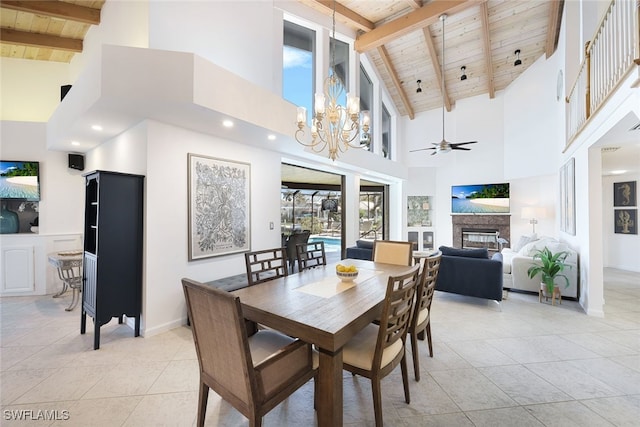 dining area featuring a glass covered fireplace, light tile patterned floors, baseboards, wood ceiling, and ceiling fan