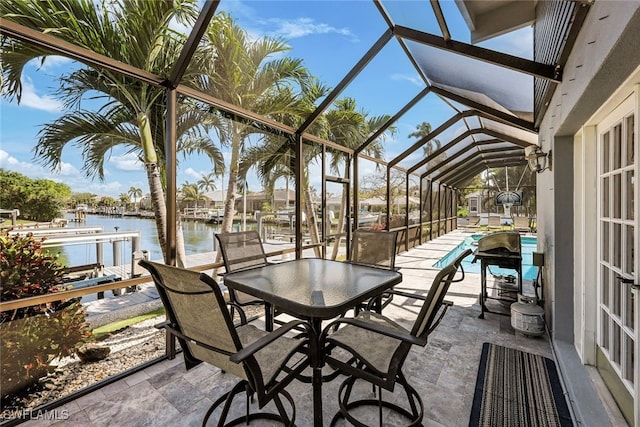 view of patio / terrace with glass enclosure, a boat dock, and a water view