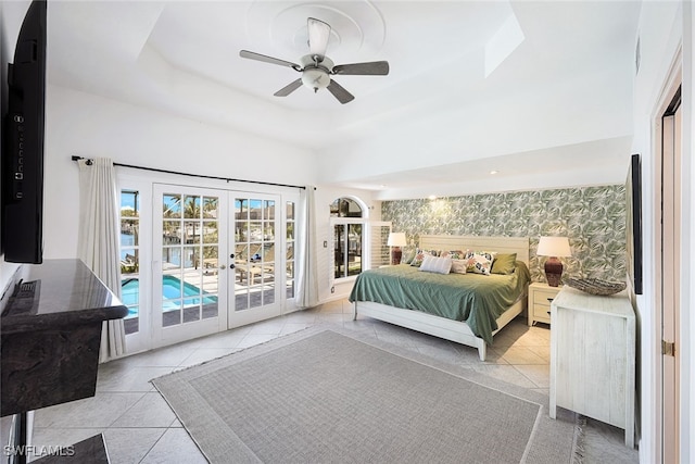 tiled bedroom featuring wallpapered walls, french doors, a raised ceiling, a ceiling fan, and access to outside