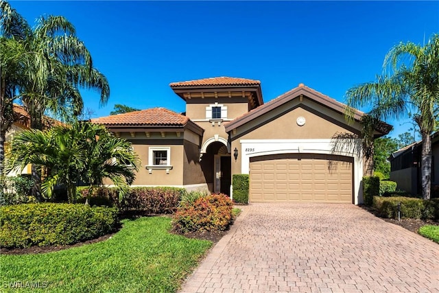 8295 Provencia Ct, Fort Myers, FL 33912 - mediterranean / spanish-style home with an attached garage, decorative driveway, stucco siding, and a tiled roof