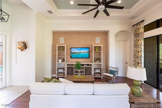 living area featuring visible vents, ceiling fan, crown molding, and a tray ceiling