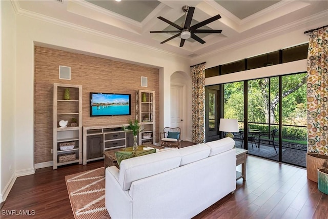 living room with dark wood-type flooring, ornamental molding, a ceiling fan, coffered ceiling, and arched walkways