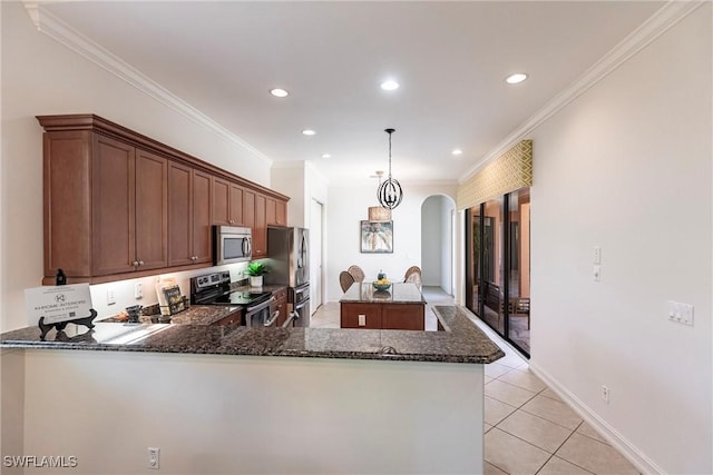 kitchen featuring dark stone countertops, a kitchen island, arched walkways, appliances with stainless steel finishes, and light tile patterned floors