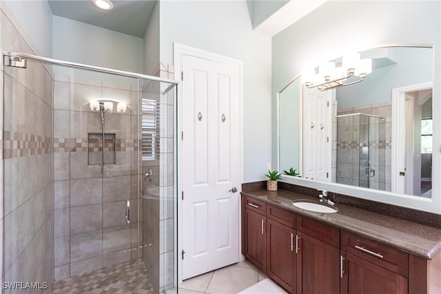 bathroom with tile patterned floors, a chandelier, a stall shower, and vanity