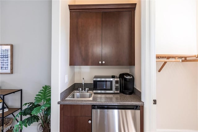 kitchen with a sink, stainless steel appliances, dark brown cabinetry, and dark countertops