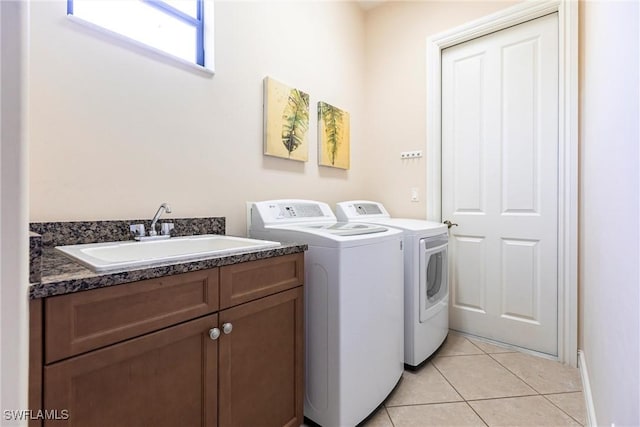 laundry area with washer and clothes dryer, light tile patterned floors, cabinet space, and a sink