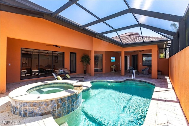 view of swimming pool with a pool with connected hot tub, a ceiling fan, and a patio area